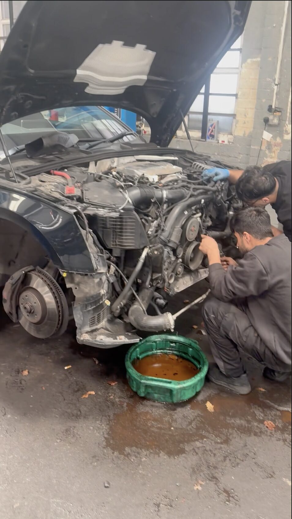 Two mechanics repairing a vehicle at FS Brand Garage
